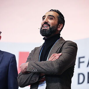FABRIK DES JAHRES - Reehman Waqaas spricht auf der Bühne und hält seine Keynote zum Thema Keynote: Automatisierte Produktionsplanung in Zeiten von Unsicherheiten