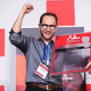 FABRIK DES JAHRES - Startup Cerpro erhält seine Auszeichnung für die Startup Challenge und steht auf der Bühne und freut sich